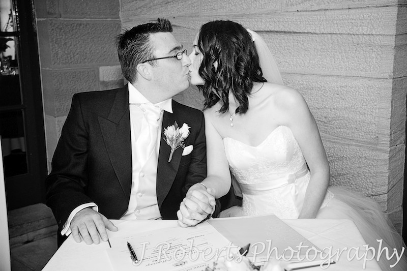 Kissing after signing the register - wedding photography sydney